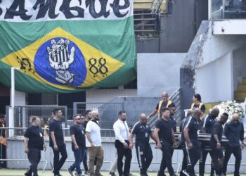 Carregado por filho, caixão de Pelé é colocado no centro do gramado da Vila Belmiro