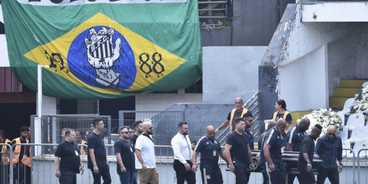 Carregado por filho, caixão de Pelé é colocado no centro do gramado da Vila Belmiro