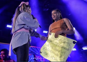 Fã que derrubou Simaria em show há 8 anos é notada por Simone Mendes após mostrar cartaz e é chamada ao palco: ‘oportunidade de me desculpar’