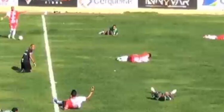 Jogadores deitam no chão após ataque de insetos durante partida de futebol no interior da Bahia